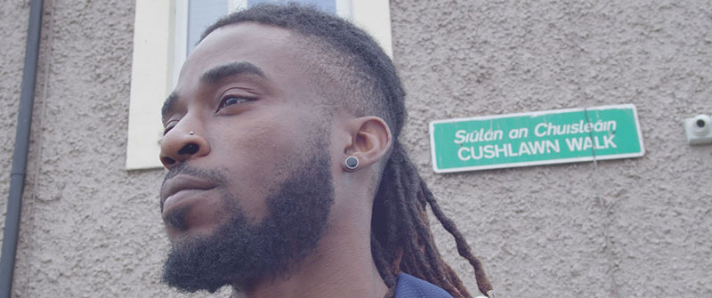 a man in front of a sign that reads 'Cushlawn Walk'