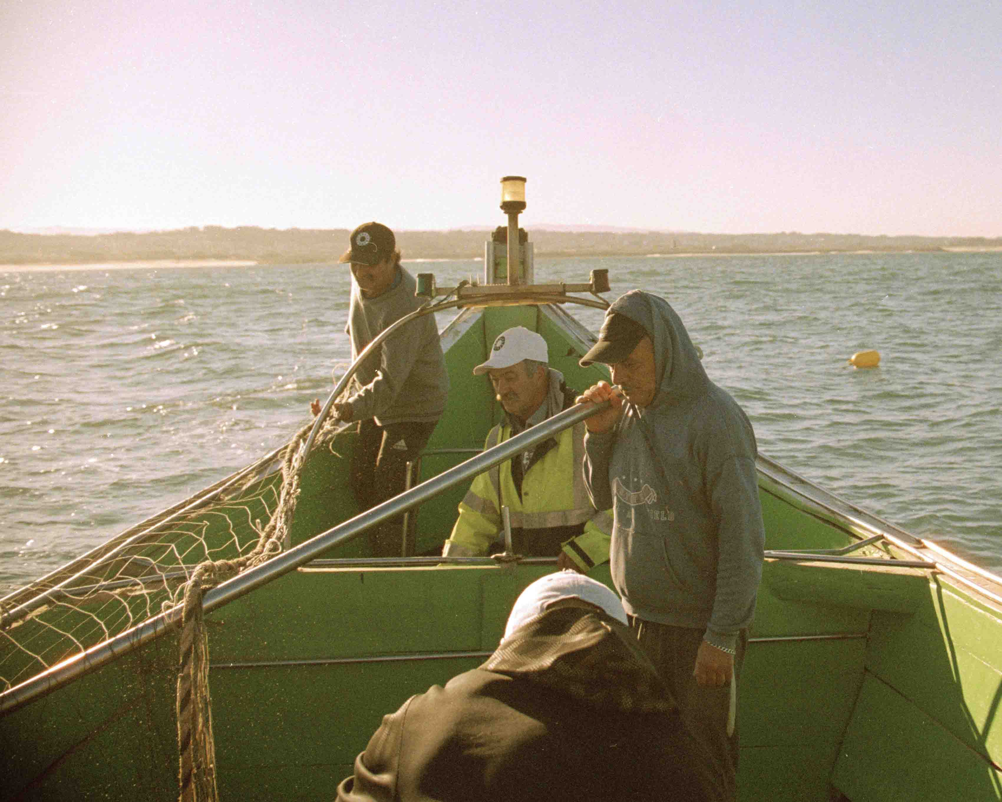 Four Fishermen working on the boat on the early hours of the morning.