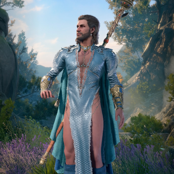 Long haired man in a blue dress in front of a flower meadow