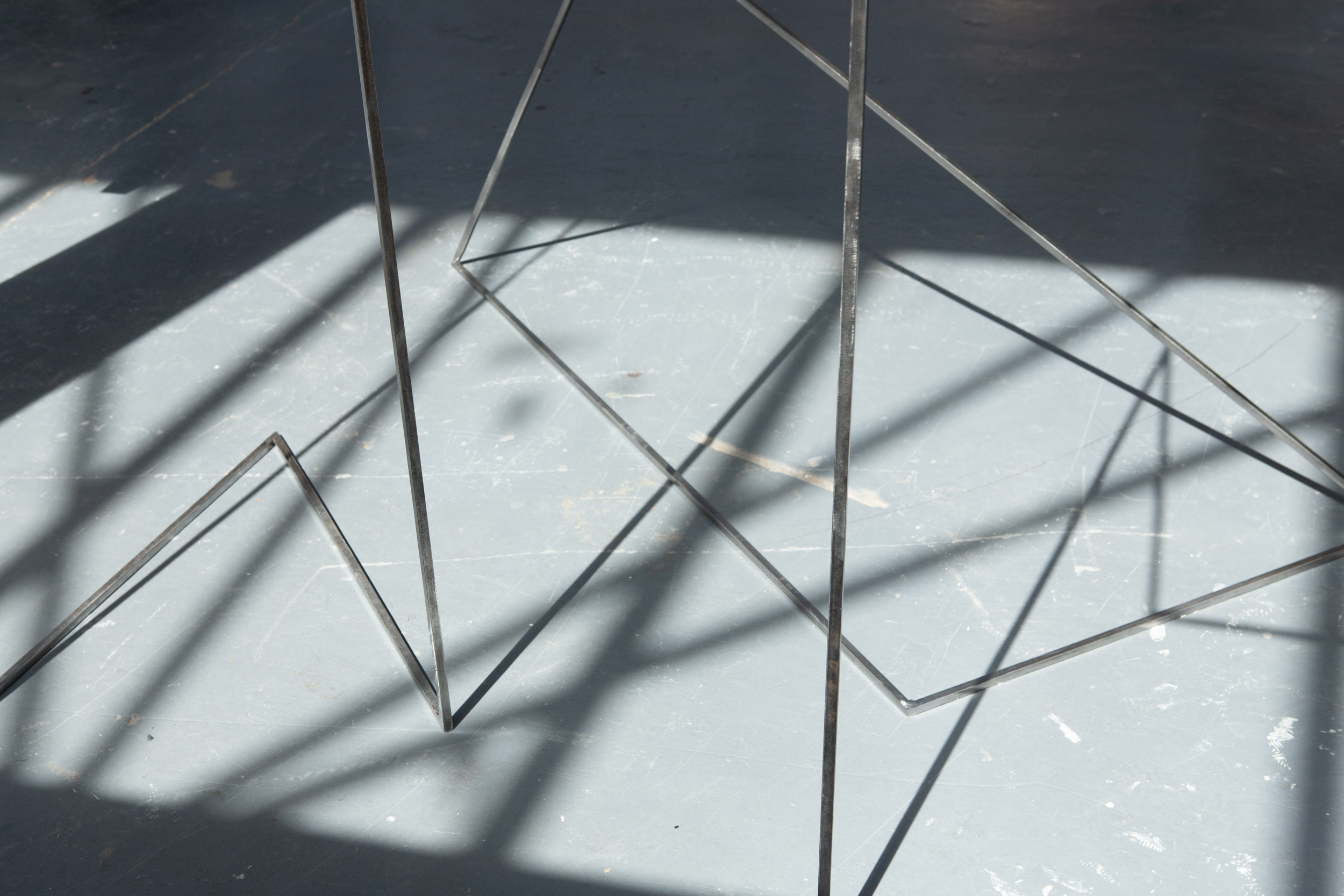 An close up image of steel sculptures and the shadows they cast on the floor