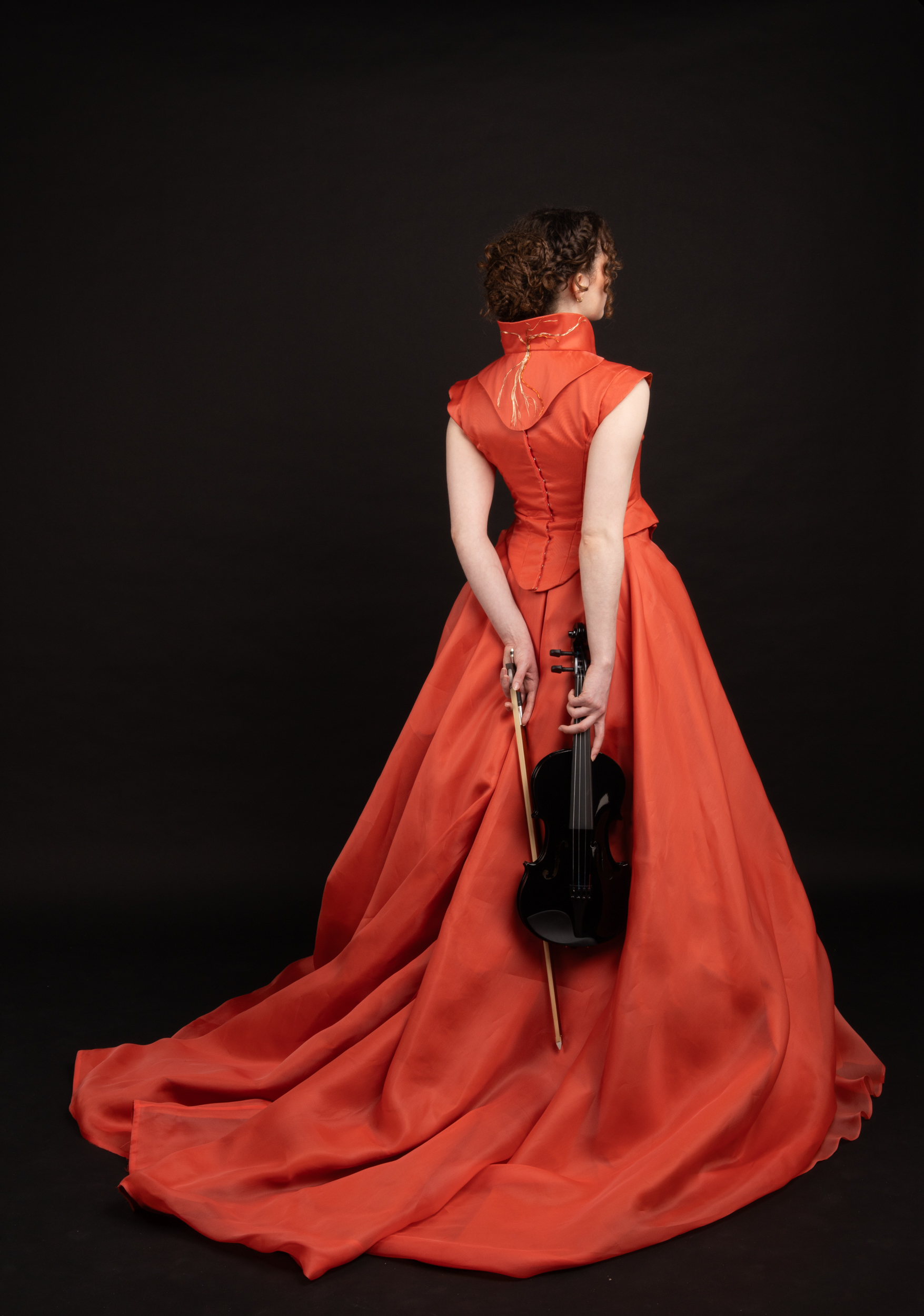 Woman in red dress holding a violin 