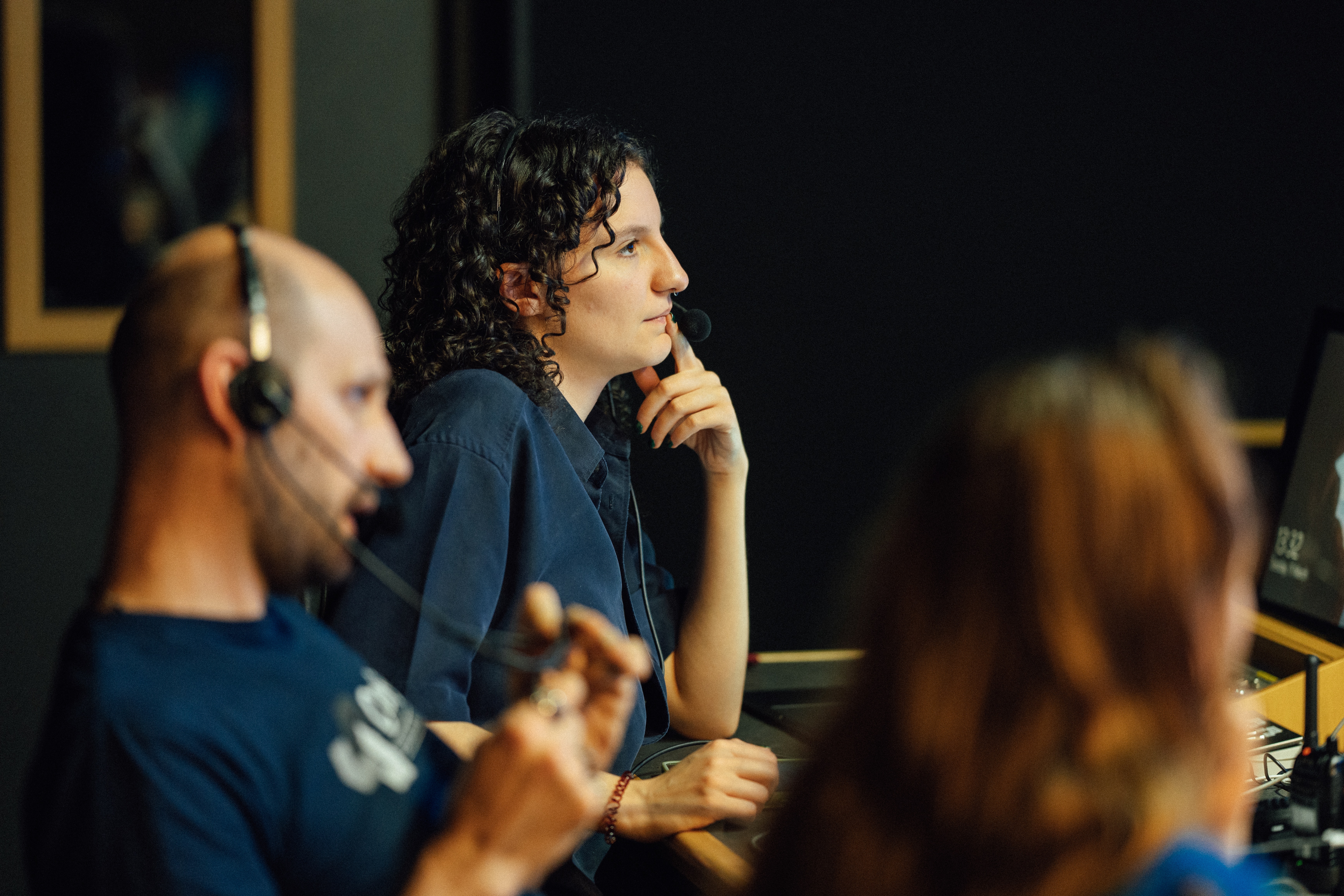 Orla in the gallery working as a PA, we can see the director and vision mixer's shilouettes