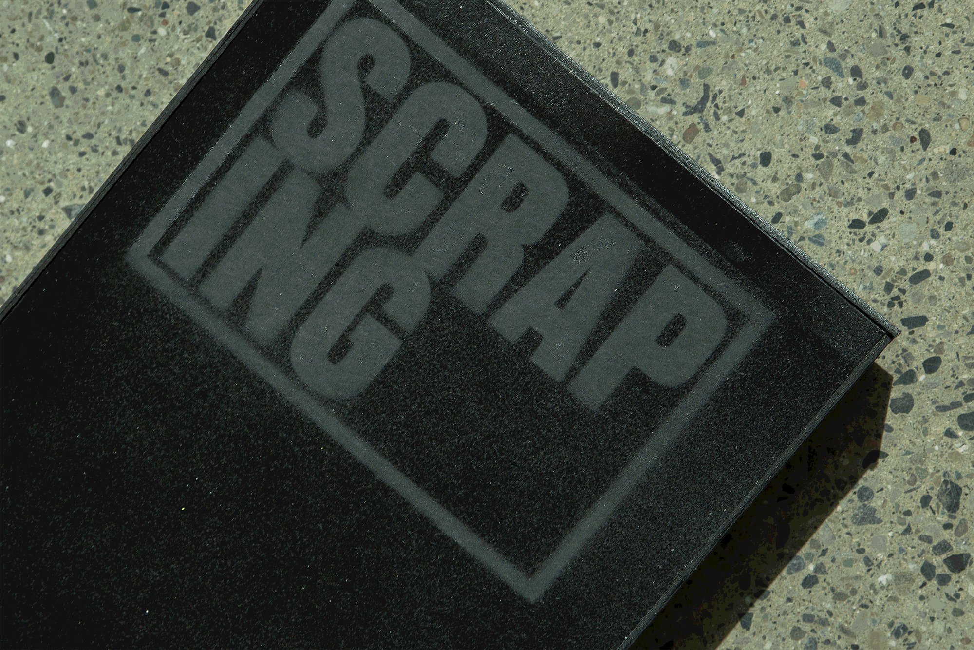 looping gif of photos showing all glossy black box with matte black title SCRAPING written at the top in a bold tall font, inside the box is an orange and black video game case in a early 2000s style with the title SCRAPING in blue