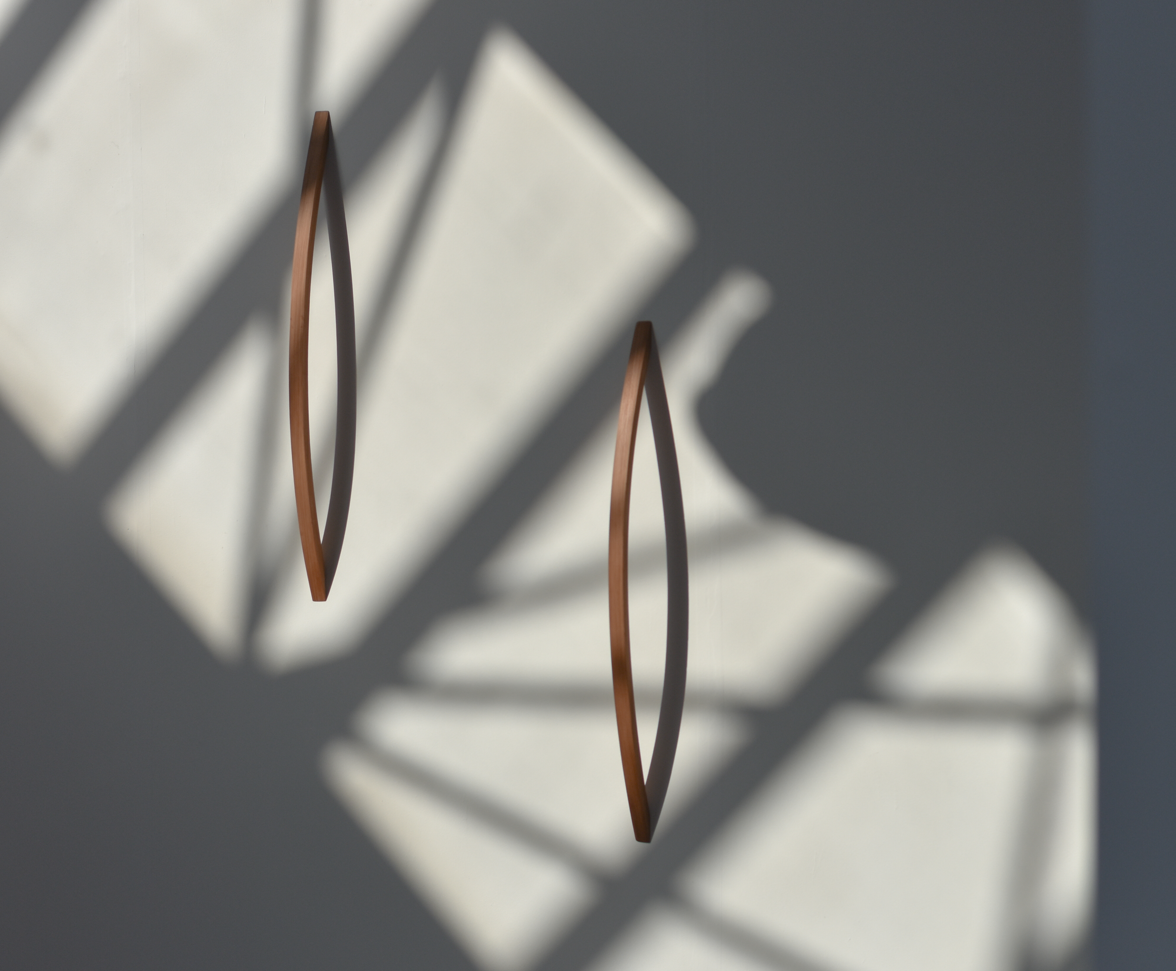 cedarwood handles bow out from a white wall