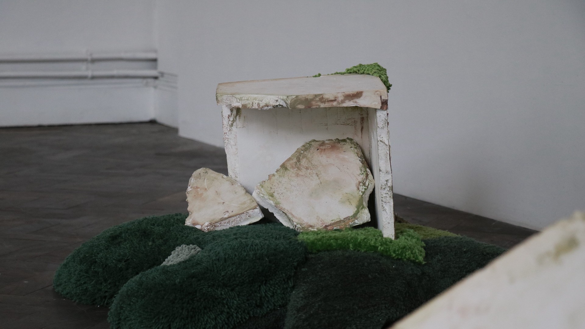 A moulded plaster block sat on top of a tufted mound.