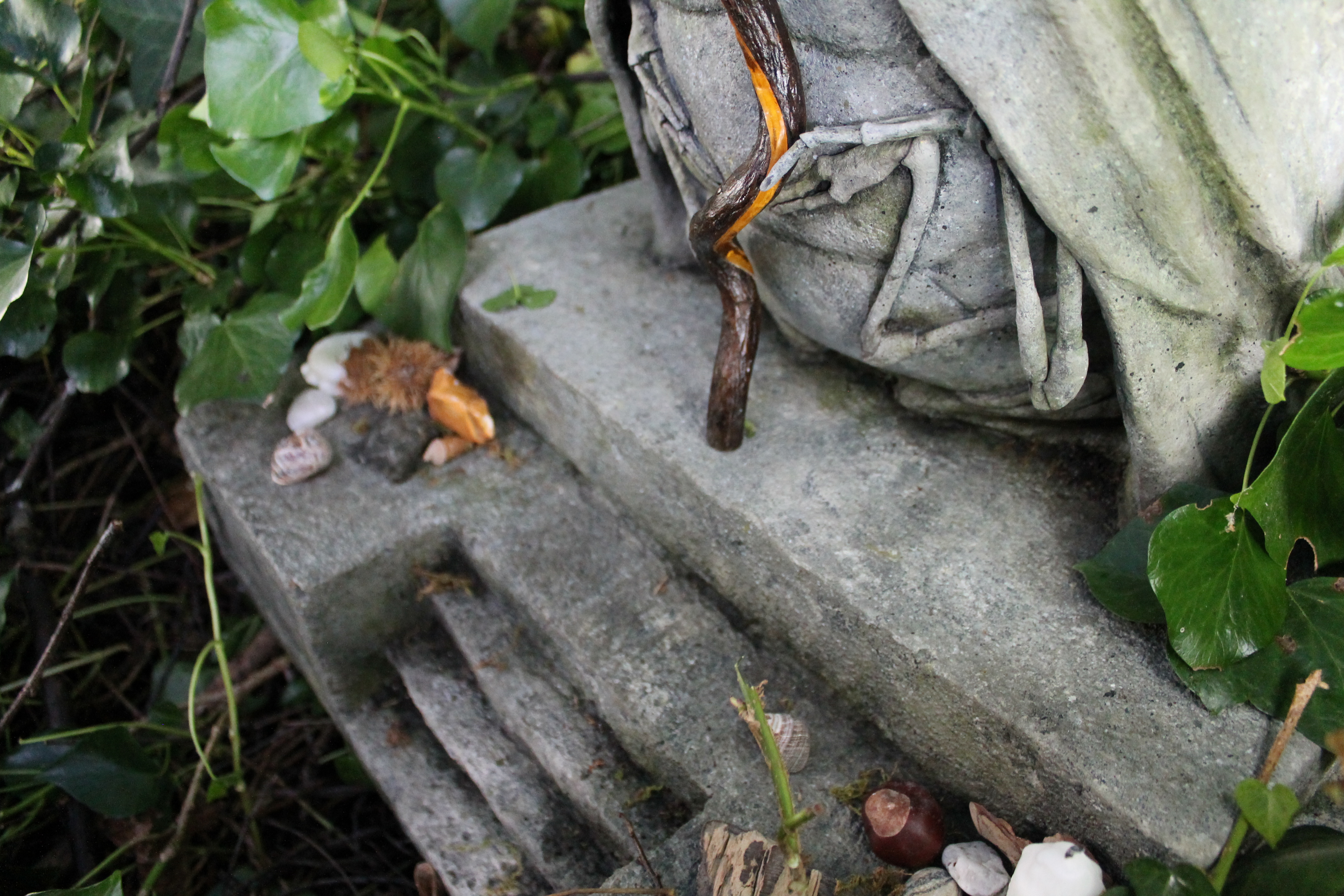 A photo of a stone-effect statue in the woods