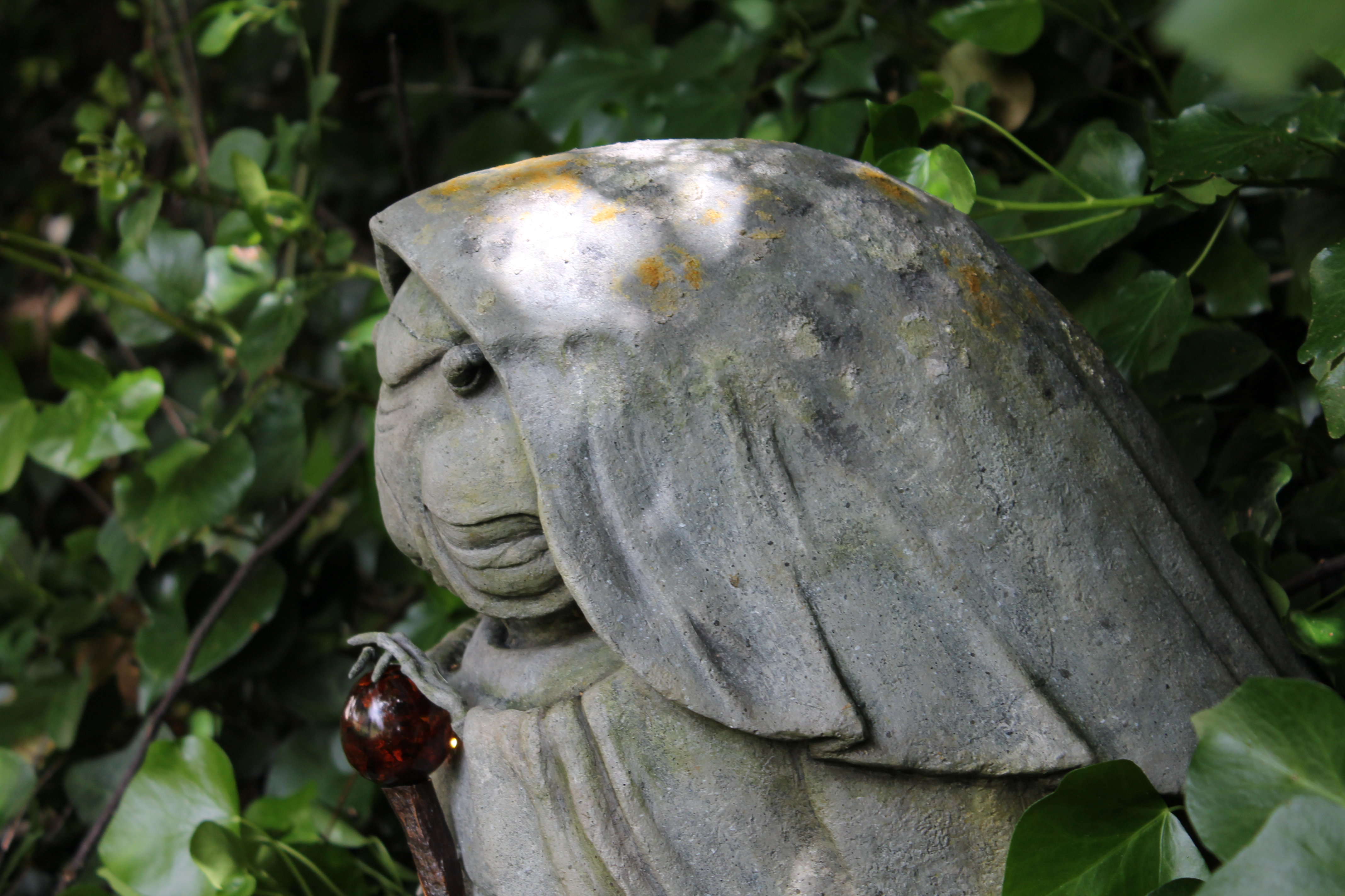 A photo of a stone-effect statue in the woods