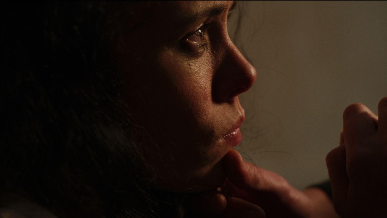 helena has her face lifted up by a mysterious hand