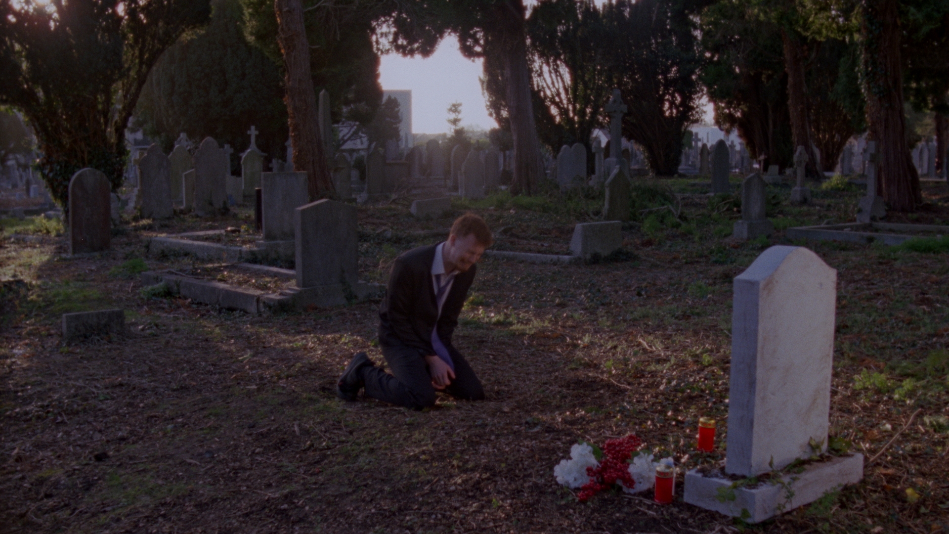 jack kneels and cries in front of a grave