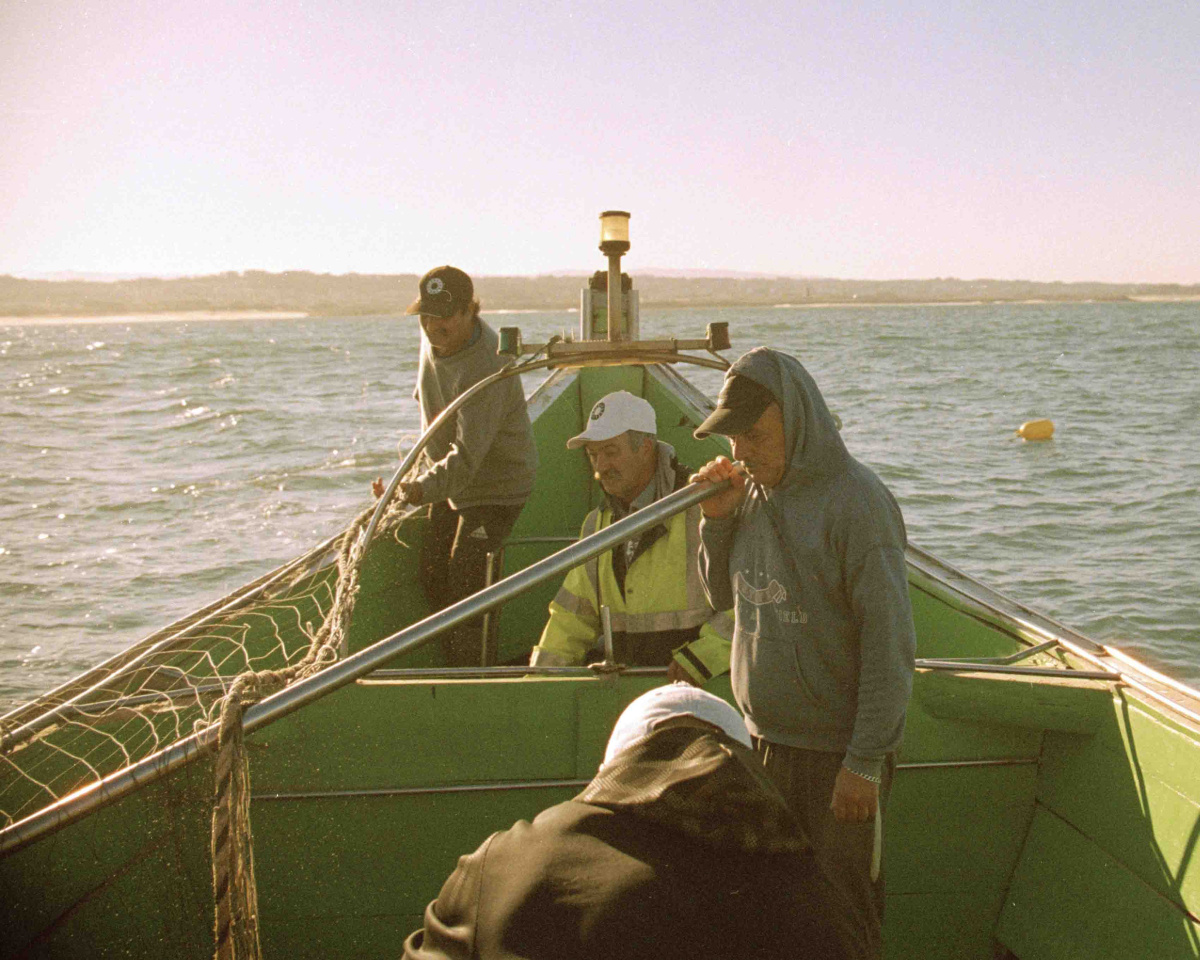 Four Fishermen working on the boat on the early hours of the morning.