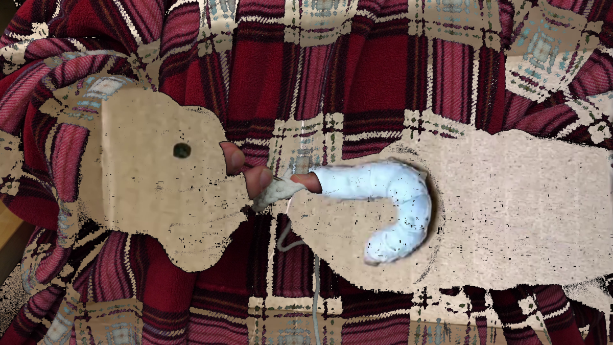 Logan Valentine sewing in the ends of the first round of crochet in making the cocoon. Their hands and a part of their clothes have been keyed out and replaced with a video of a silk moth making a cocoon.