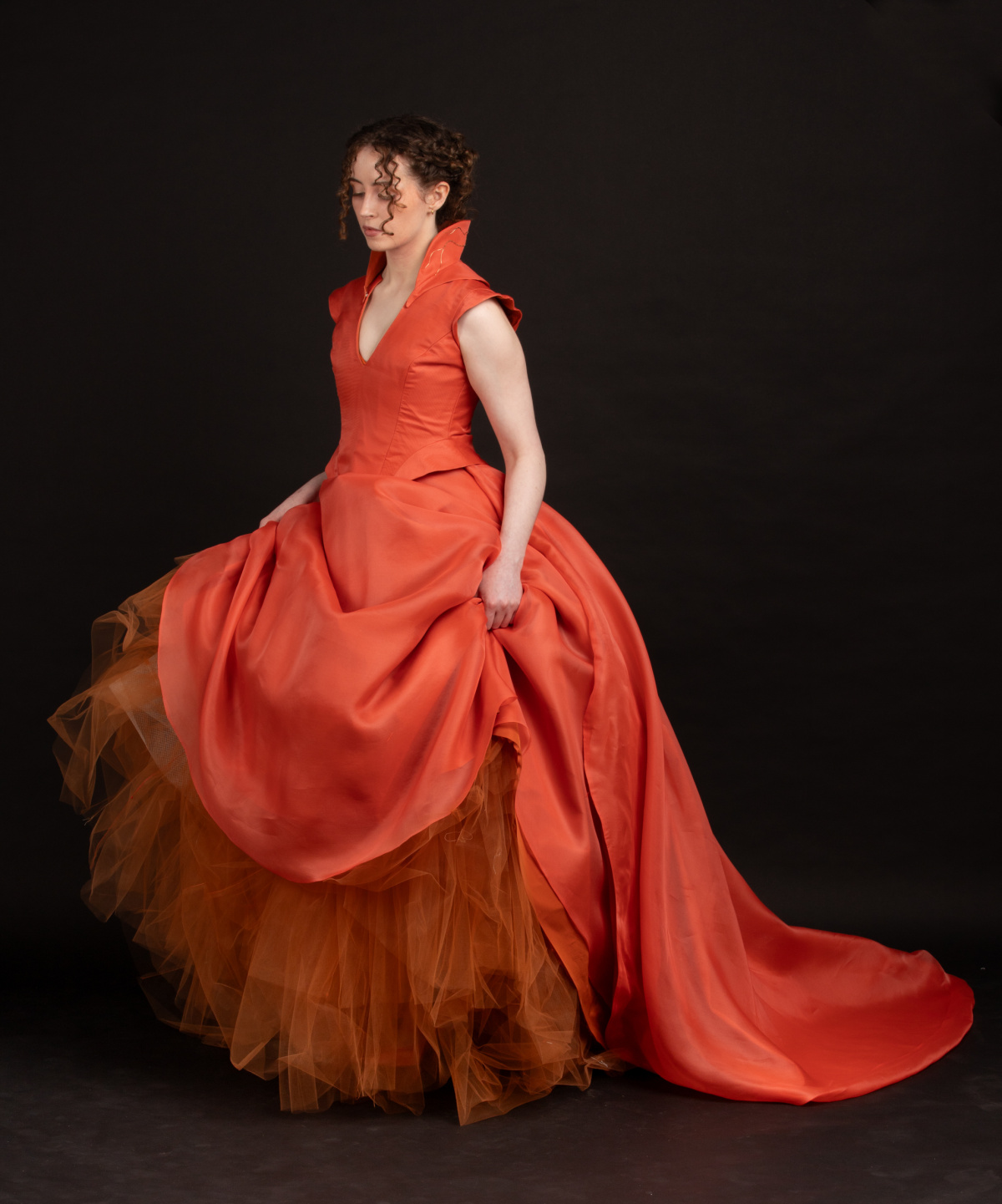 Woman in red dress lifting the skirts