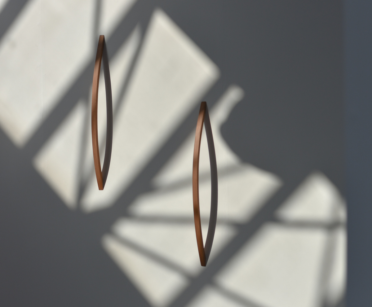 cedarwood handles bow out from a white wall