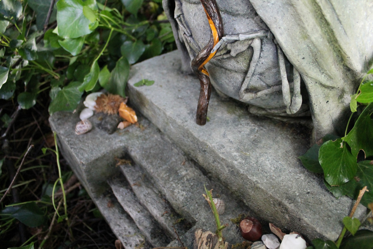 A photo of a stone-effect statue in the woods
