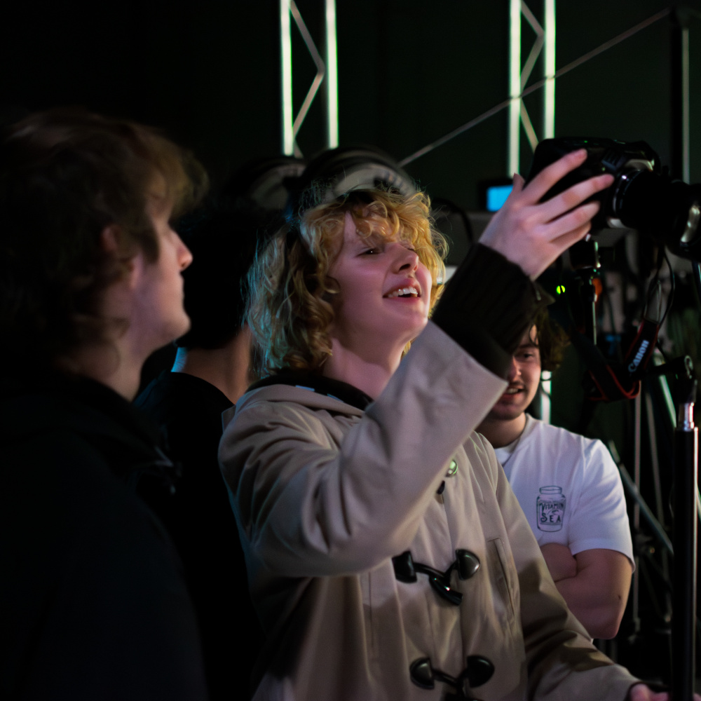 man smiling as he adjusts a camera